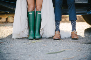 Bride in rain galoshes and groom in navy polka dot socks